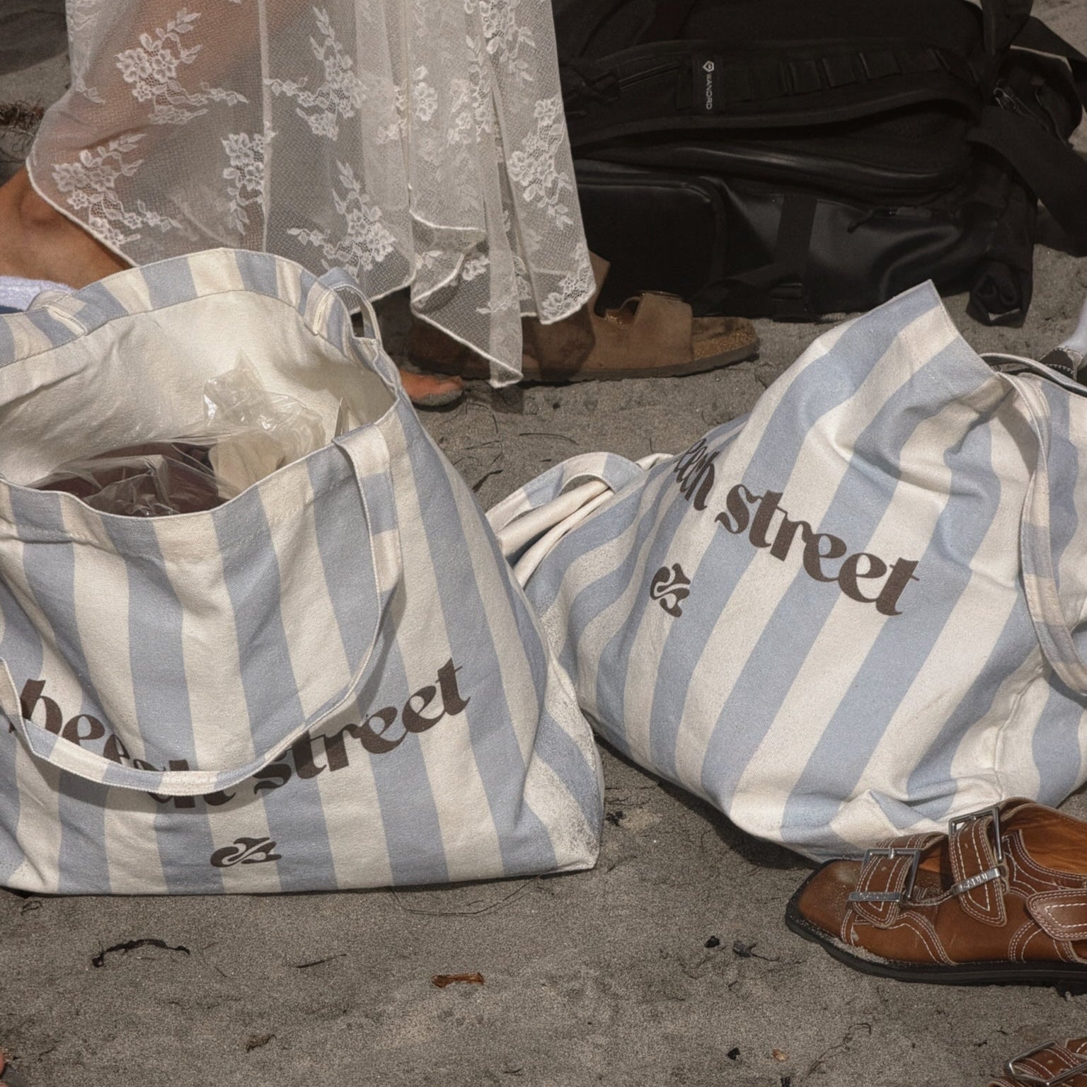 Two striped bags with 'High Street' branding on a concrete surface.